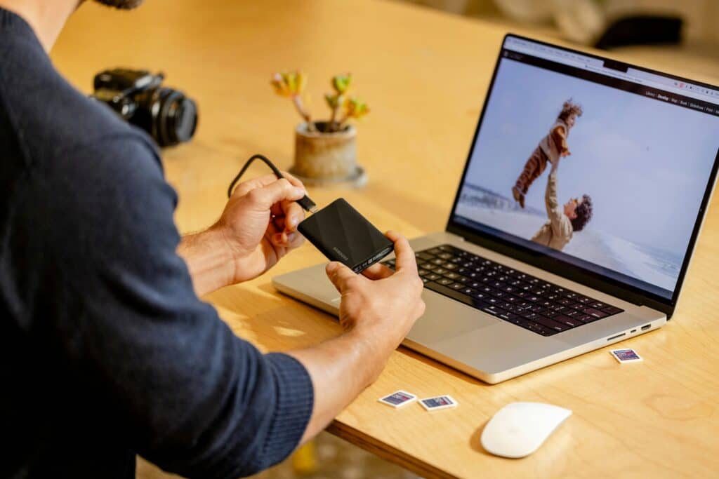 Person using a laptop and external storage drive